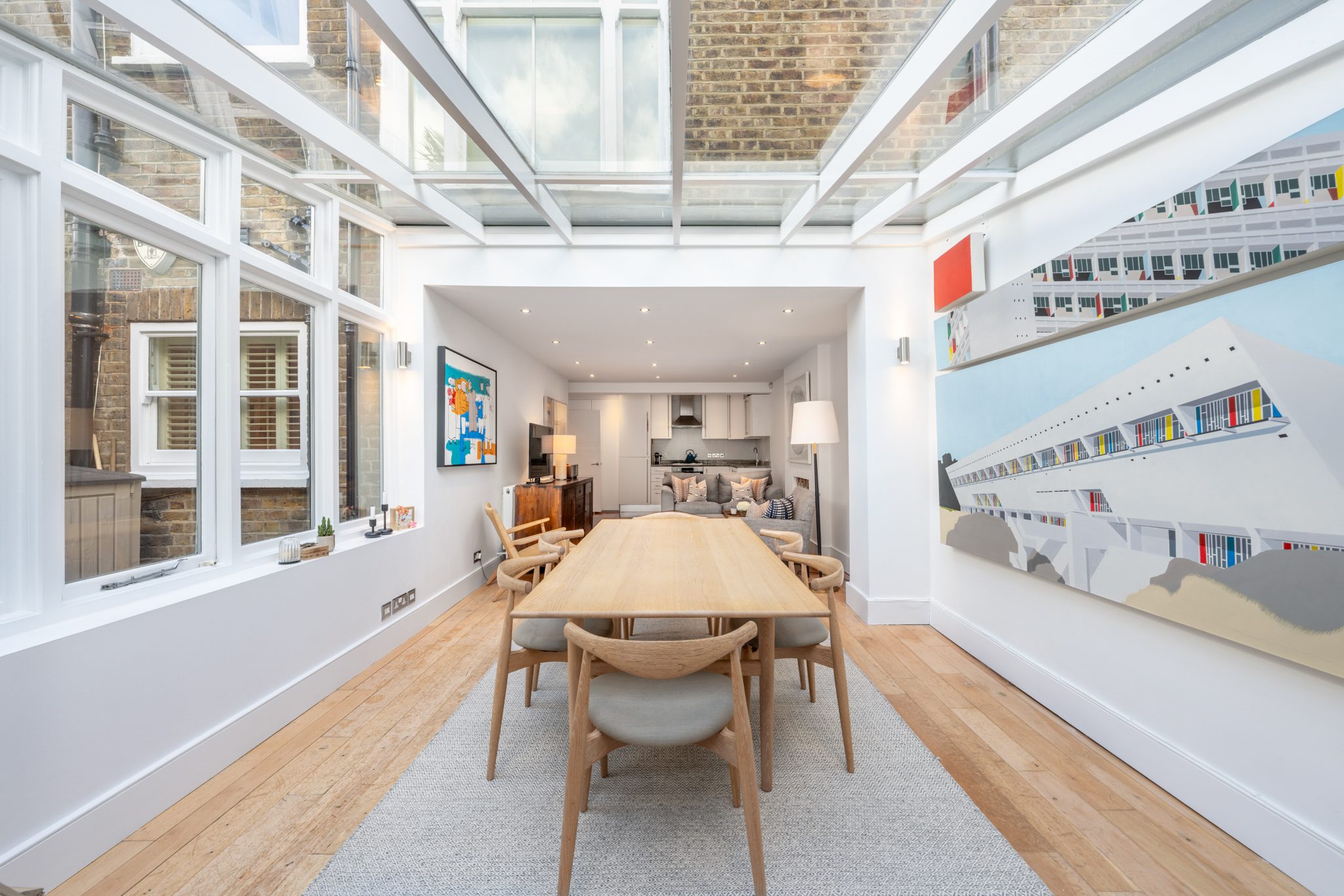 Bright dining room with glass roof, artwork and open-plan interior layout