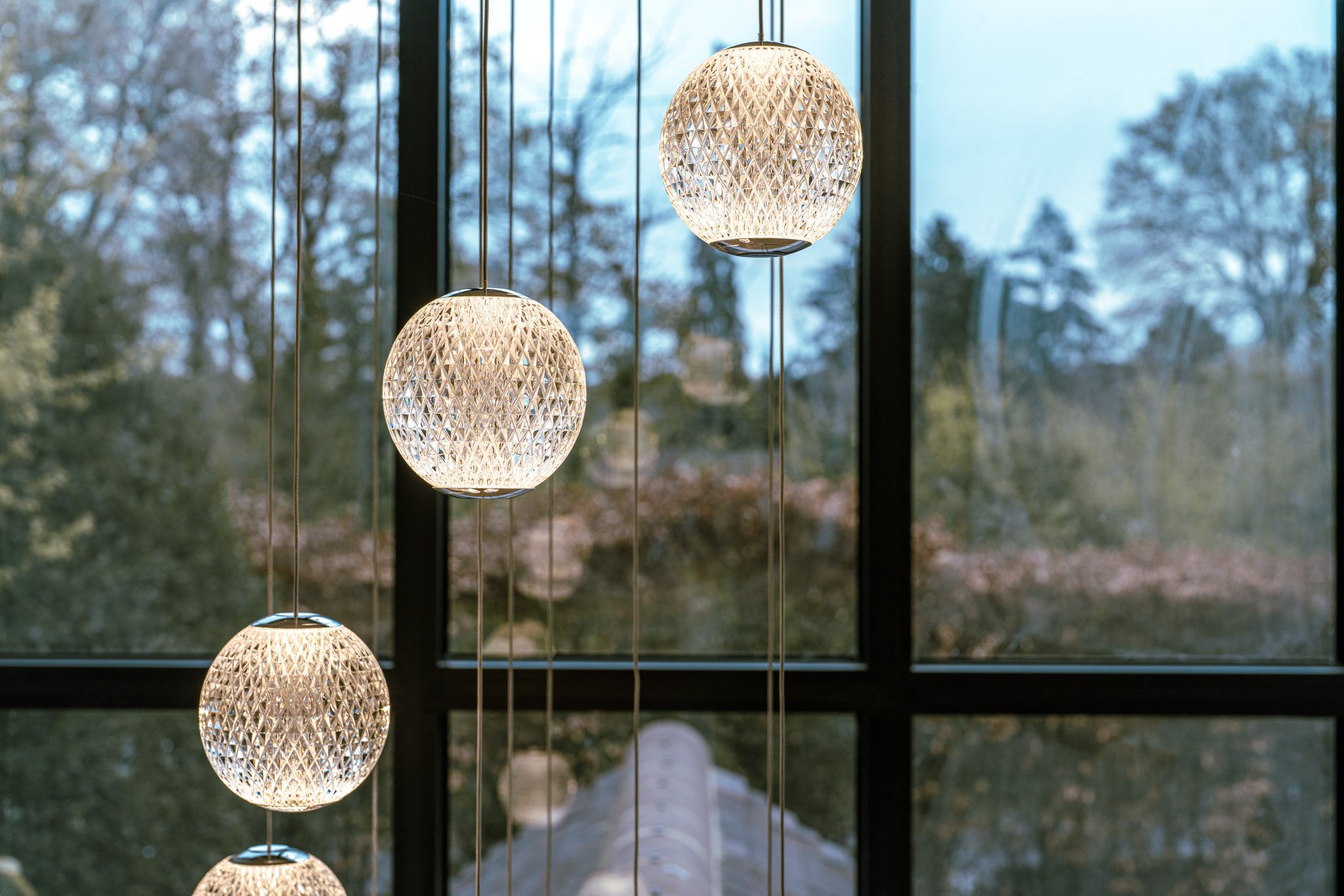 Decorative pendant lights beside large windows, captured as part of interior property photography