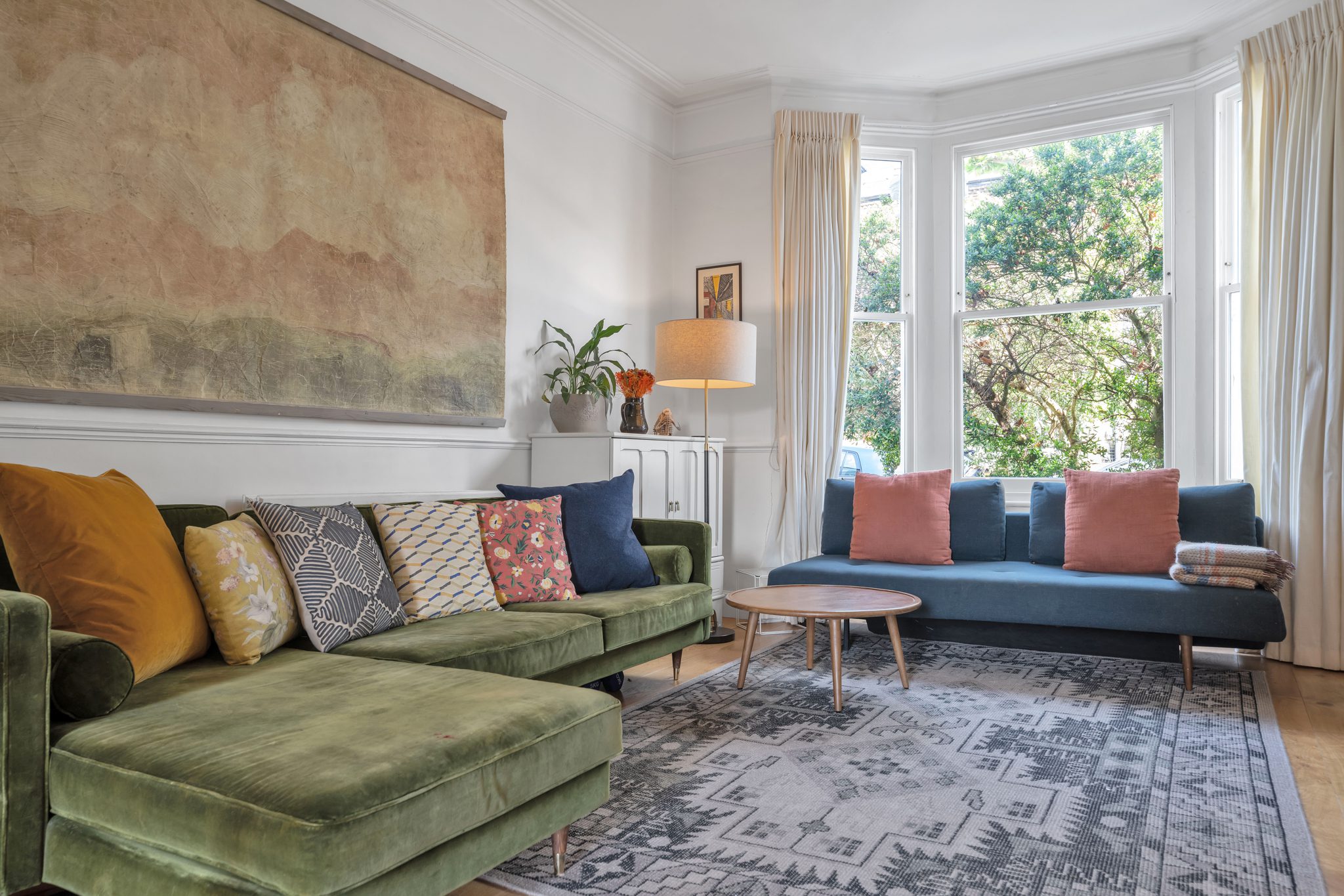 Colourful living room with bay windows, natural light and styled seating area