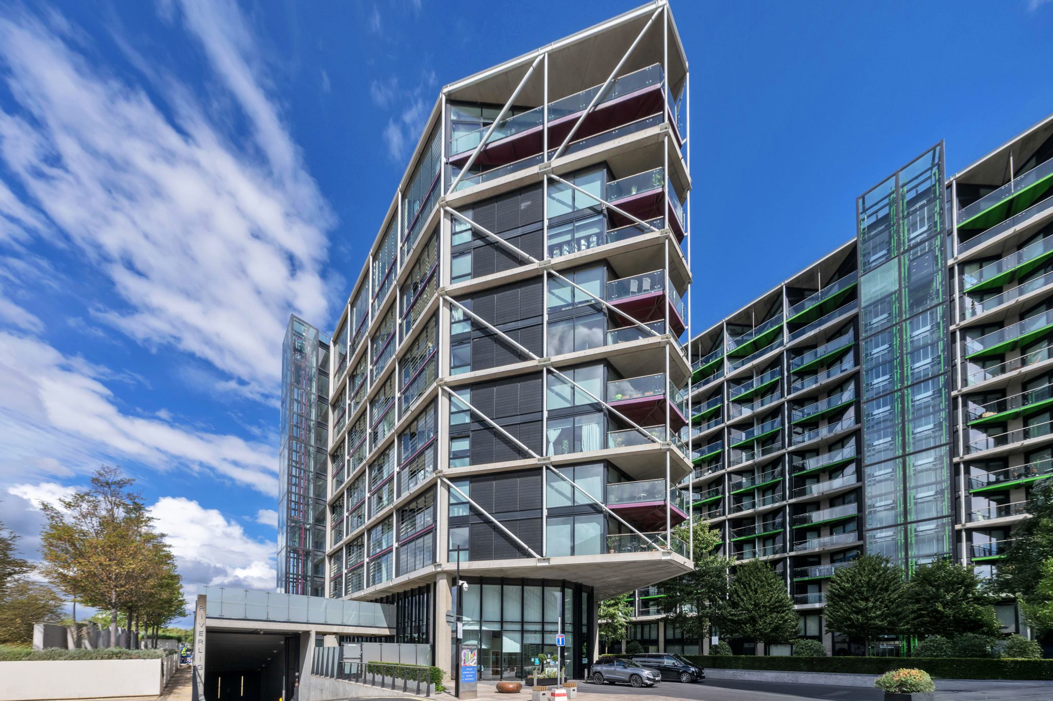 Exterior property photography of a modern London apartment building under a bright blue sky