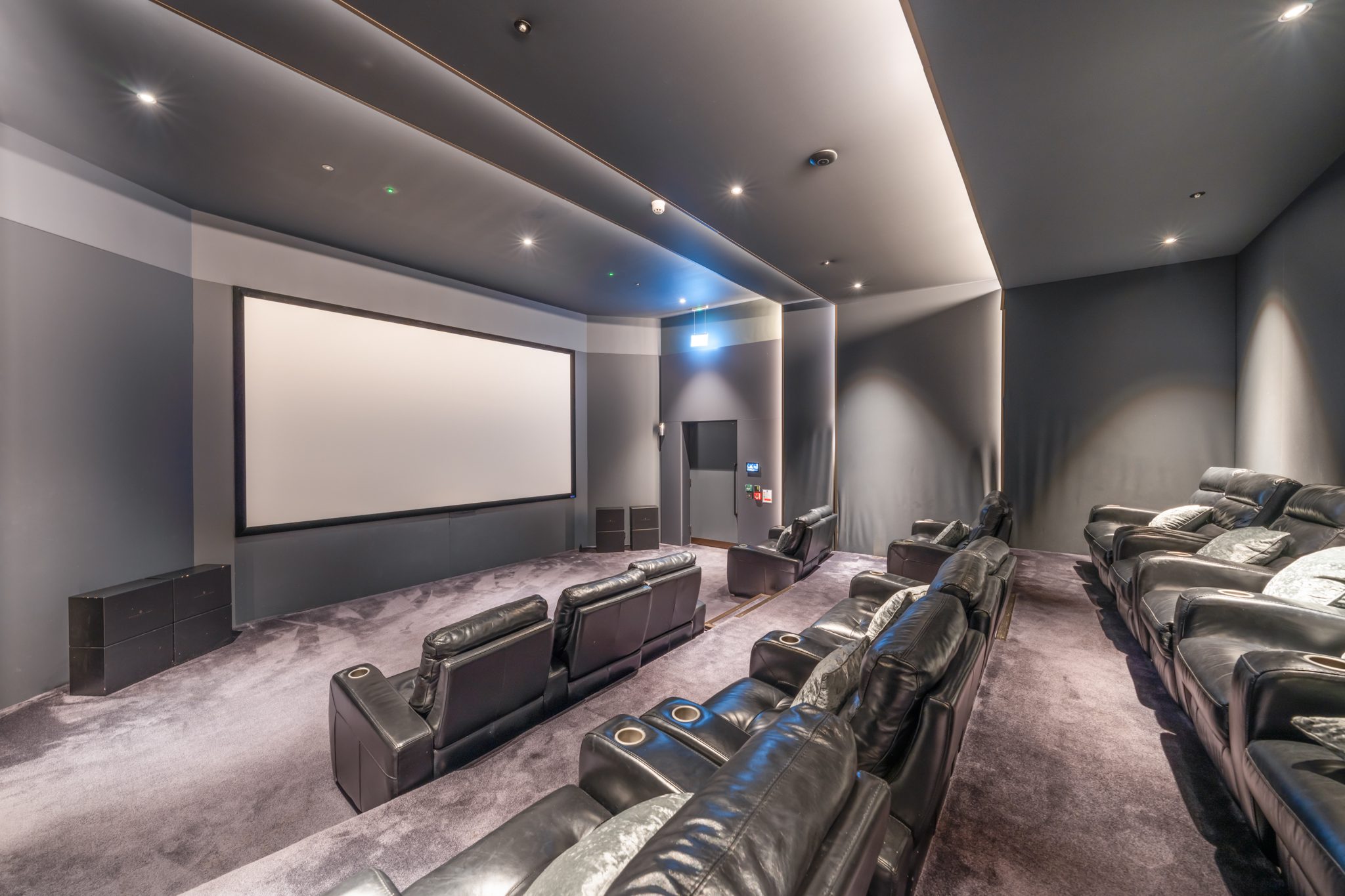 Private cinema room with leather seating and projector screen in a luxury property