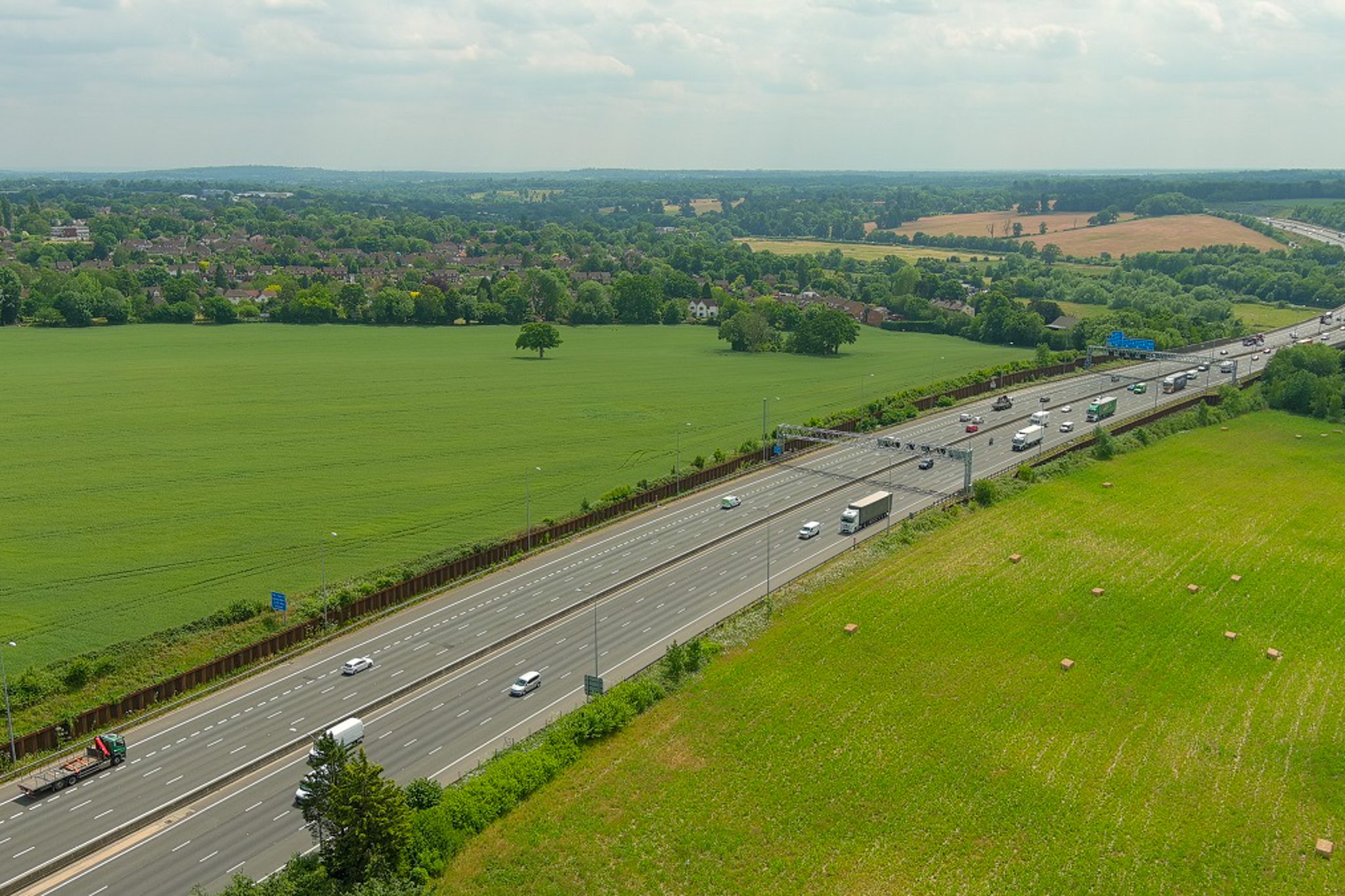 Aerial real estate photography showing road access and surrounding fields
